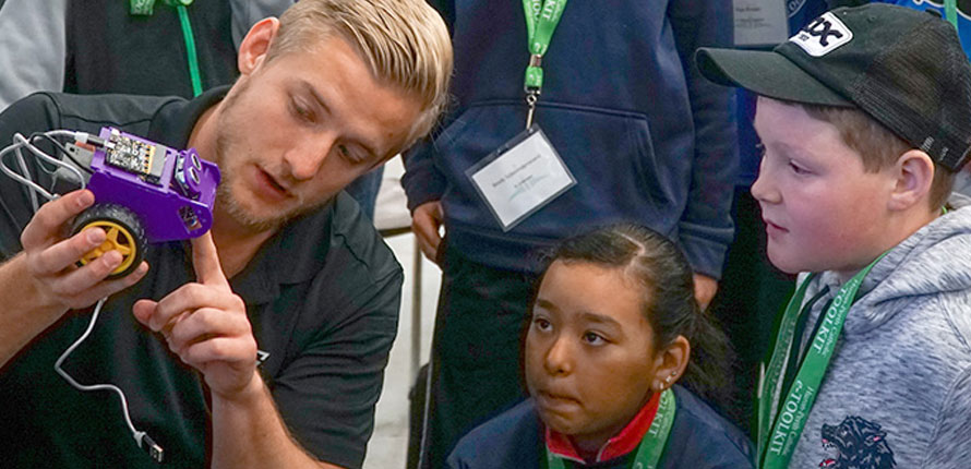 man shows device to children