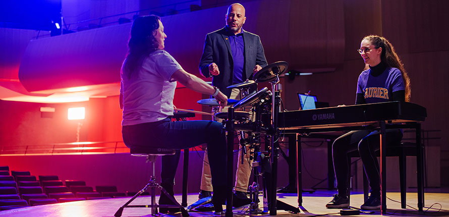 Demian Kogutek directing people playing drums and piano