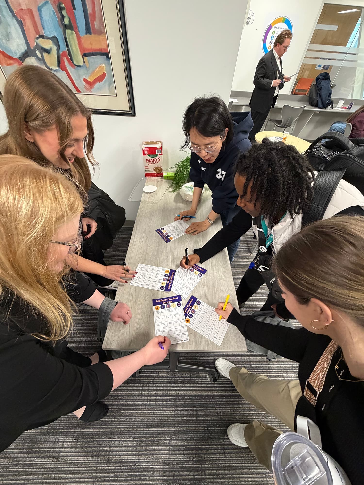 Students filling in bingo cards at a table