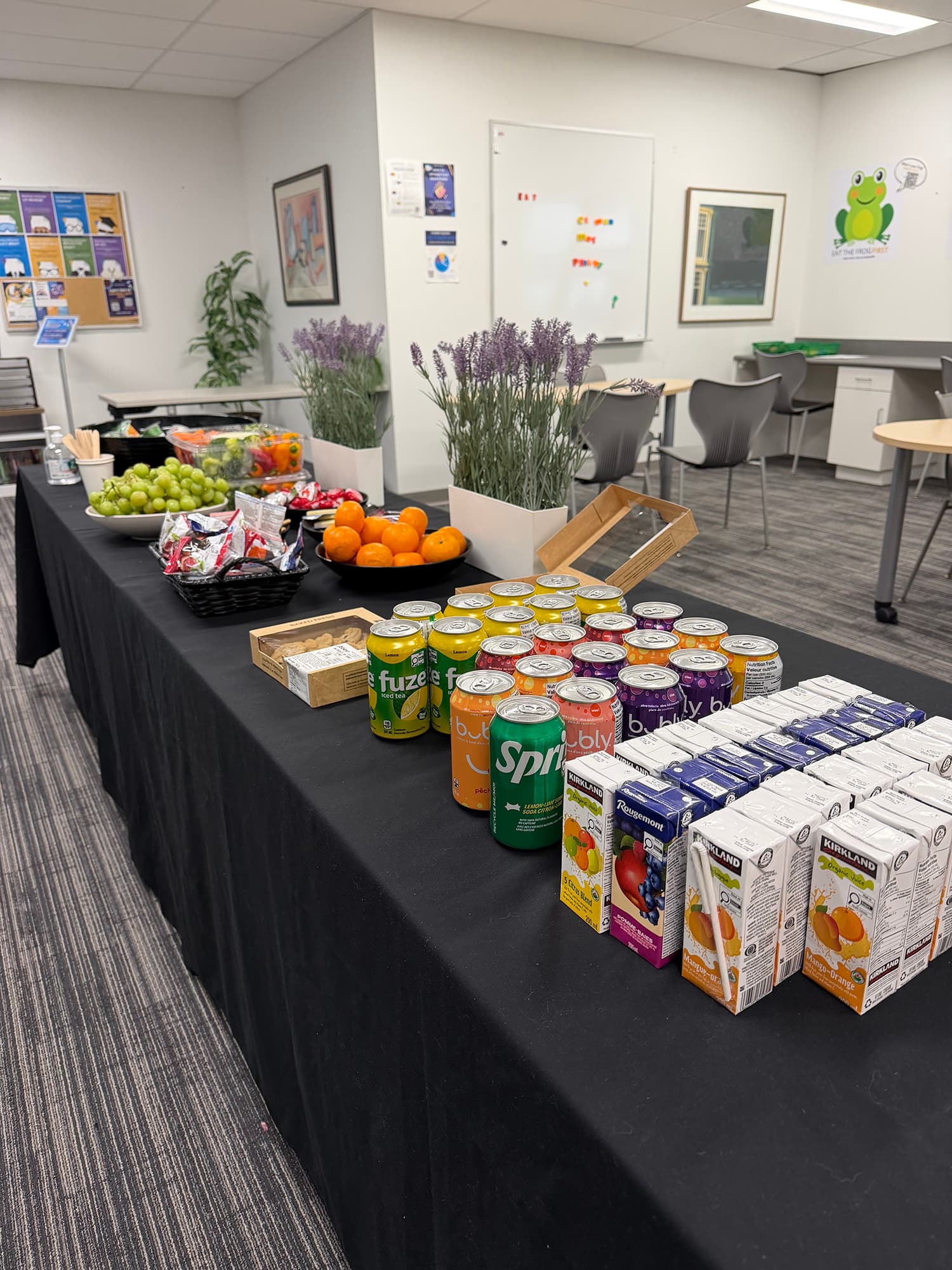 A food table with drinks, snacks and flowers