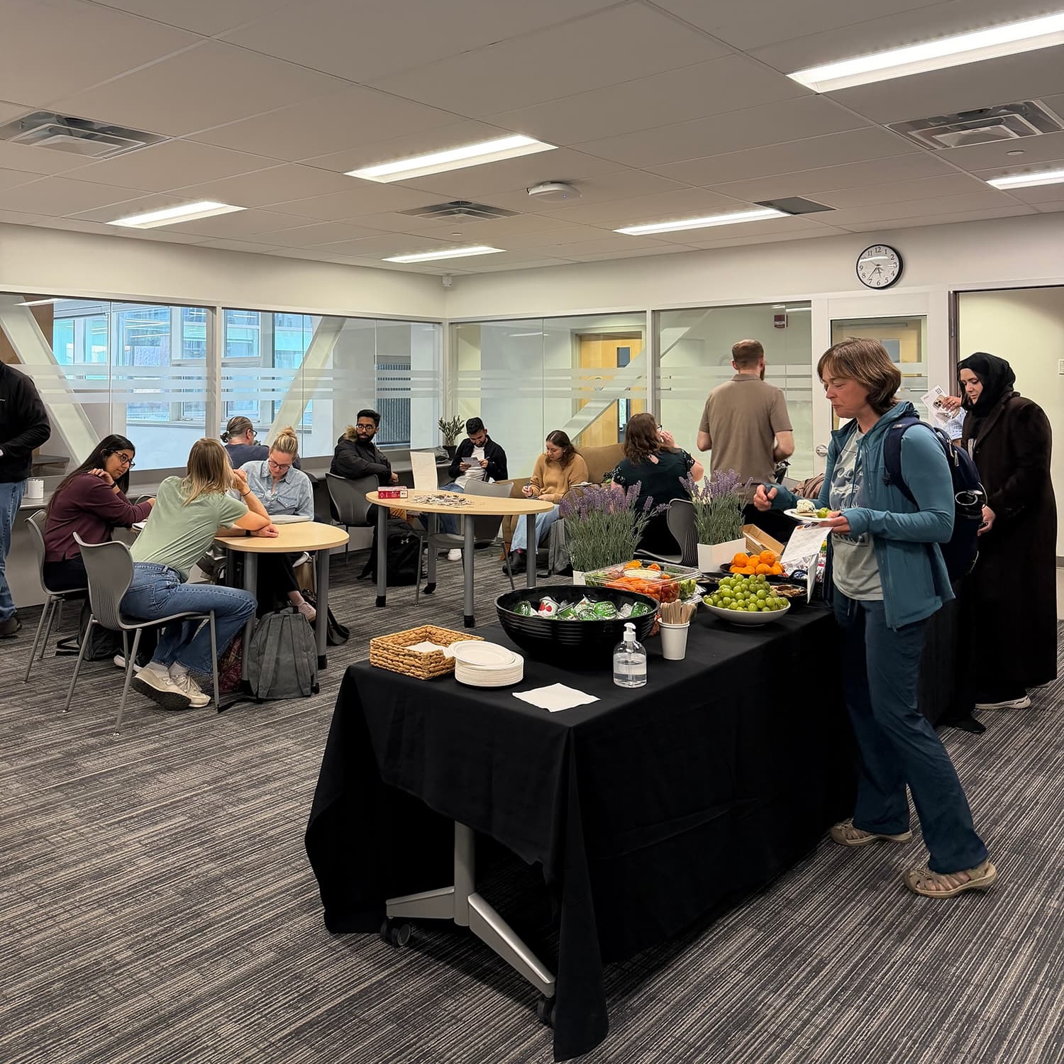 A groups of students mingling and collecting food from a table