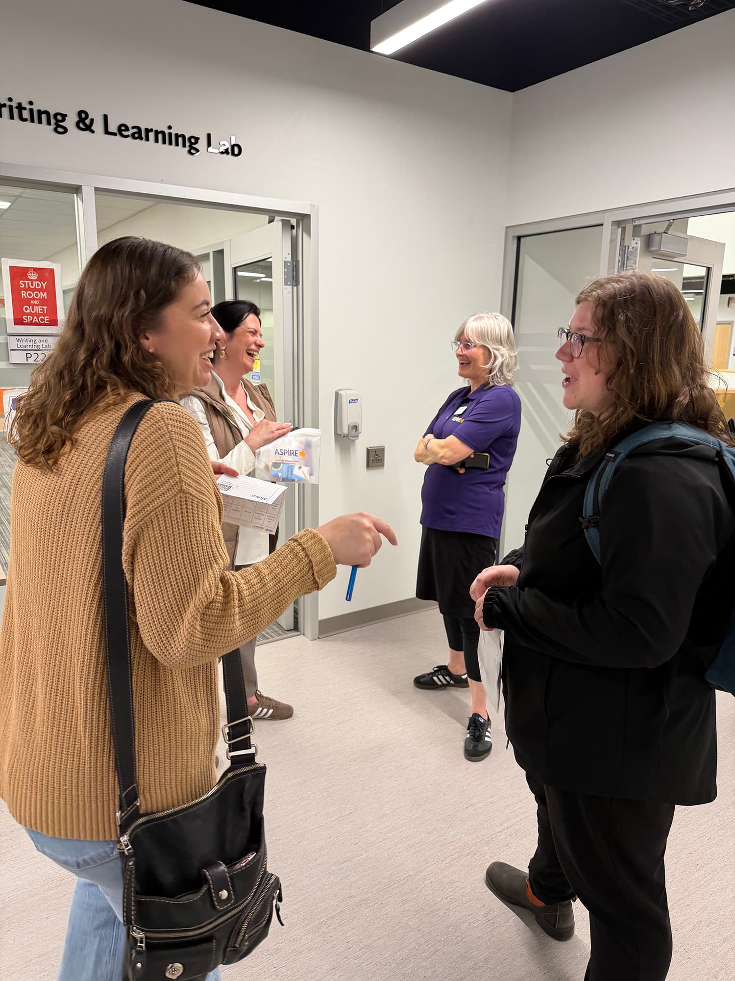 Students speaking with a volunteer in a hallway