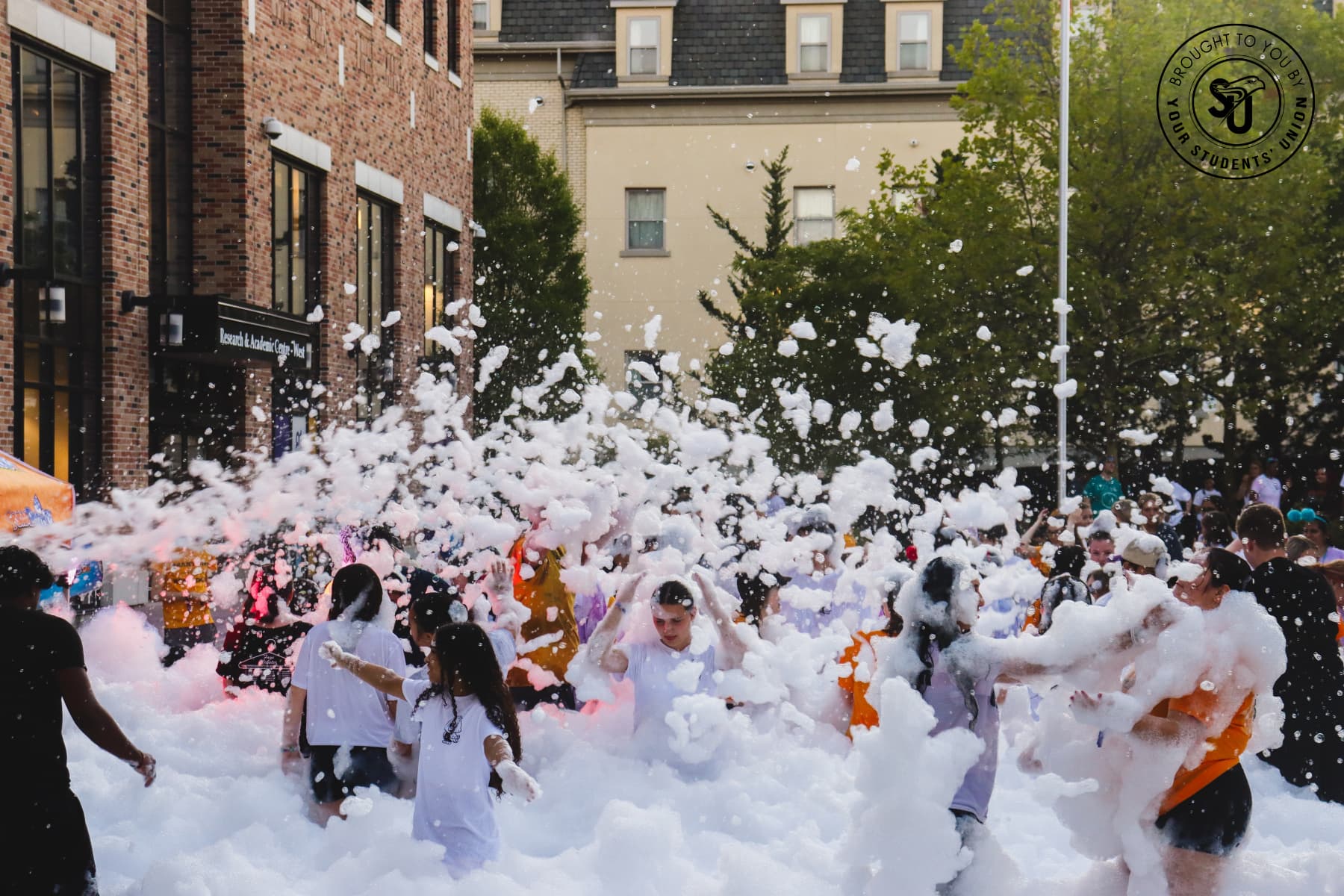 Students at foam party in the courtyard of the Research and Academic Centre