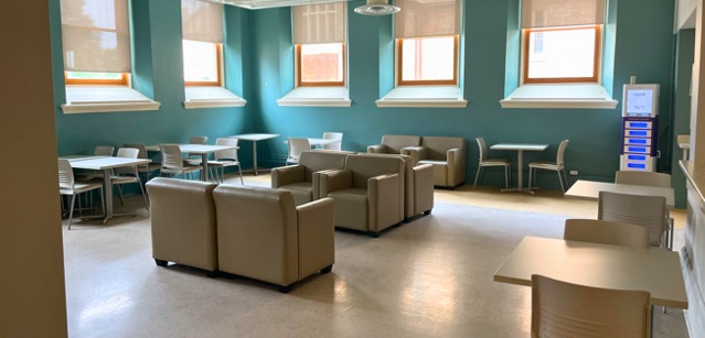 Room with lounge seating in the centre and desks lining the walls