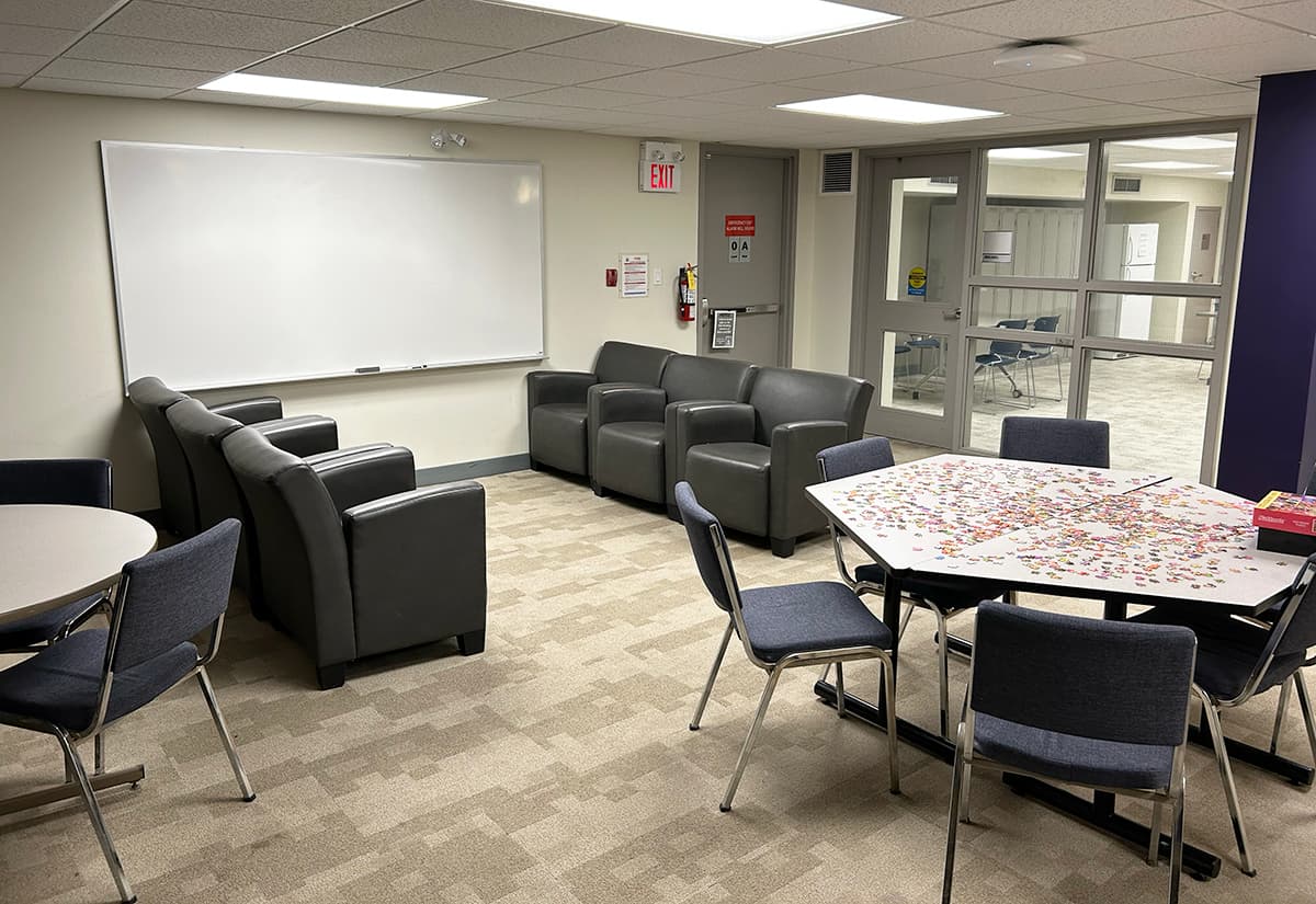 Tables and lounge chairs in front of a white board