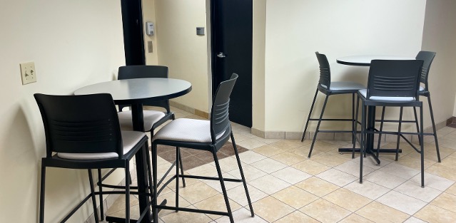 Two tables against walls in the corner of a room