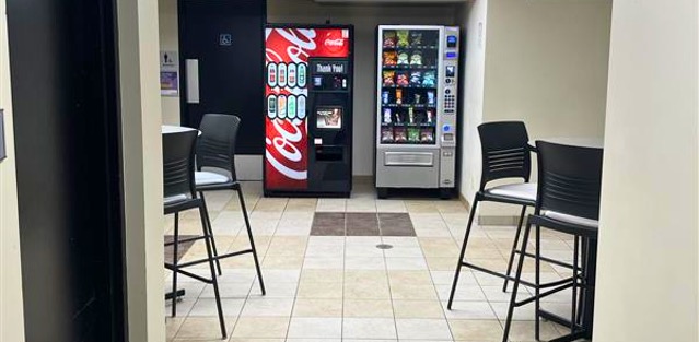 Vending machines in a room with tables on either side