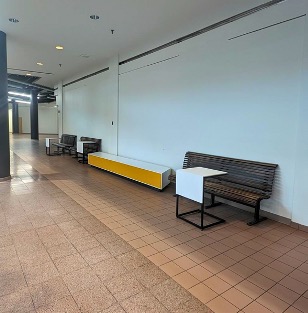 A hallway with bench seating and small tables