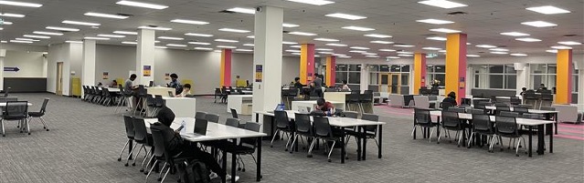 Large open space with rows of desks in between colourful pillars