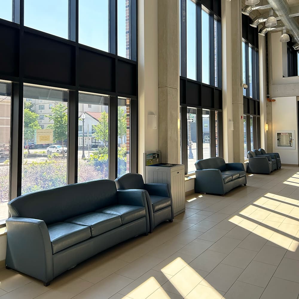 Lounge couches and chairs along a wall of large windows