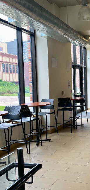 A group of tables in front of large windows
