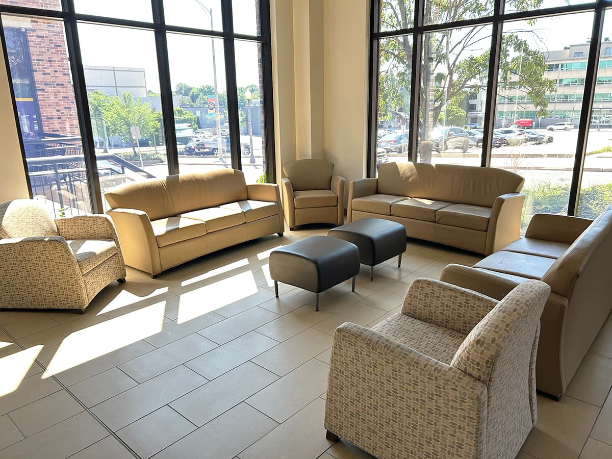 Lounge couches, chairs and ottomans in from of large glass windows