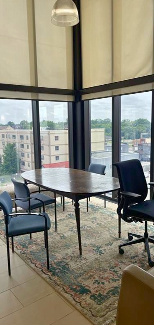 A dining table in the centre of a room with large windows