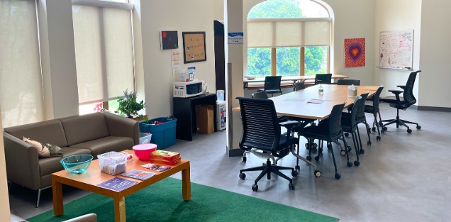 A long table in the centre of the room next to a couch and a coffee table