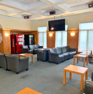 Lounge seating with tables in between chairs and vending machines in the corner