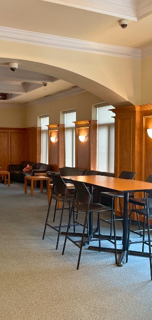A long desk under an arch with lounge seating in the background