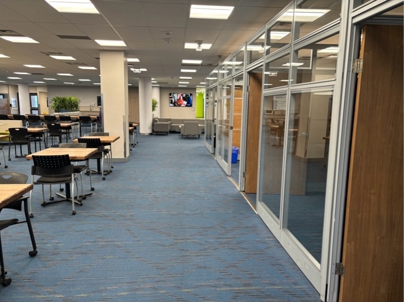 Hallway with desks to the left and study rooms to the right