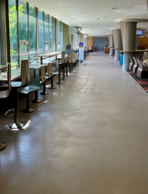 Hallway with a row of tables in front of a window