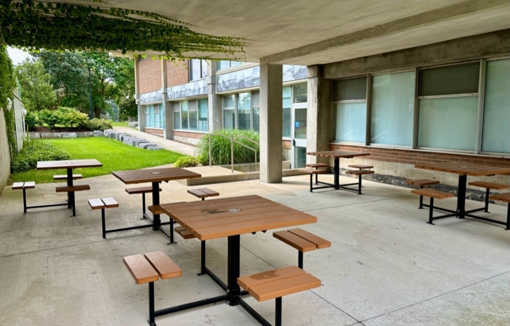 Concrete area with patio tables under an overhang