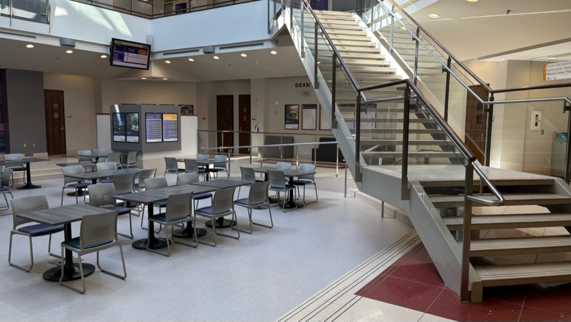 Group of tables under a large staircase and balcony