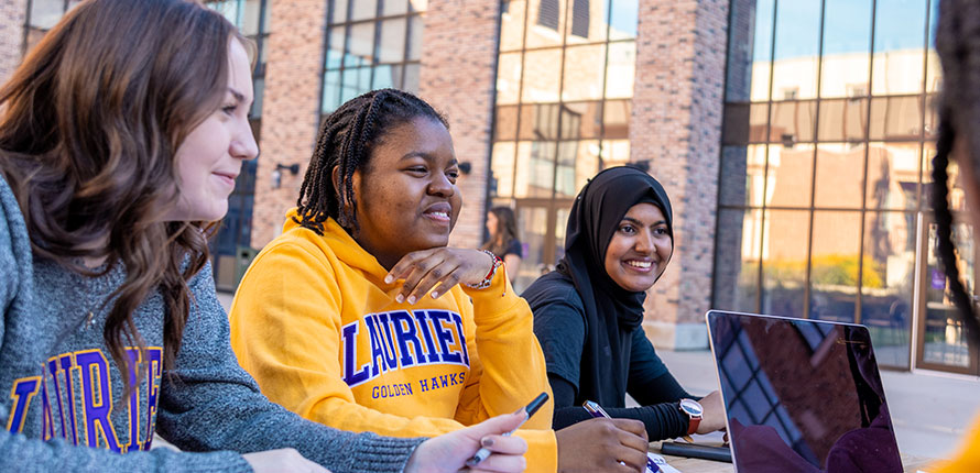 Students outside of RAC building talking.