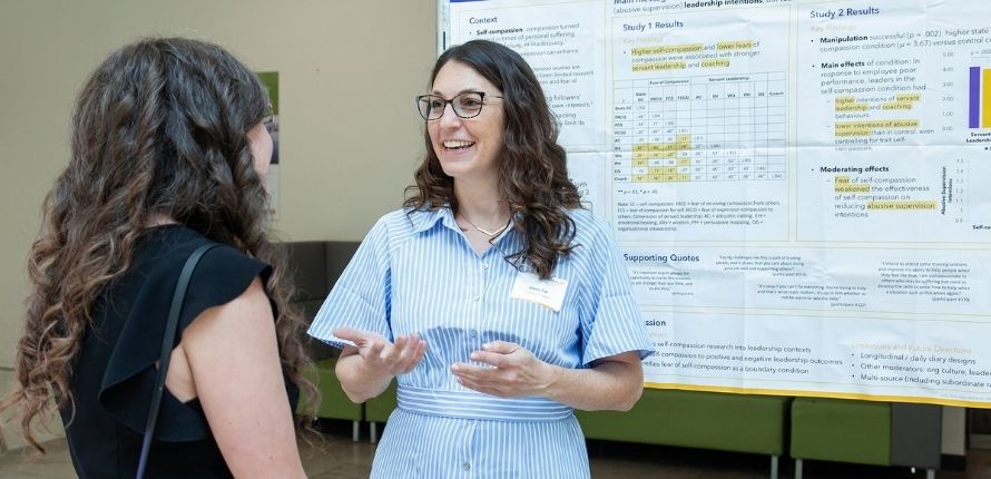 Elana Zur presents her poster to an onlooker