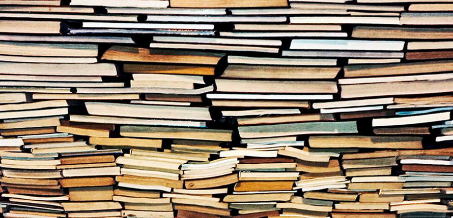 A pile of books showing their spines and pages