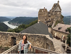 Kira Omelchenko posing in front of castle and natural landscape