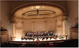 Full ensemble and choirs performing on stage