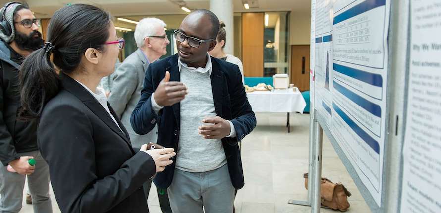 people talking near a research banner