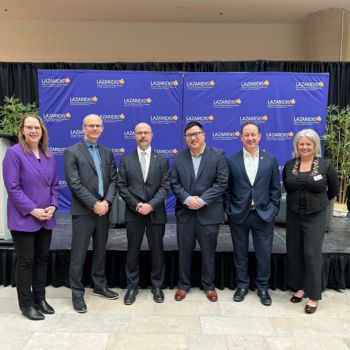 A group photo of the university president and Economic Outlook panellists