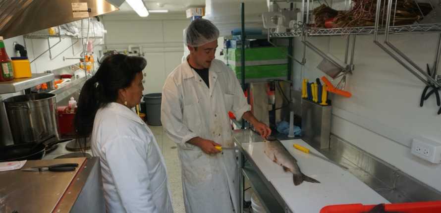 A participant learning how to filet fish