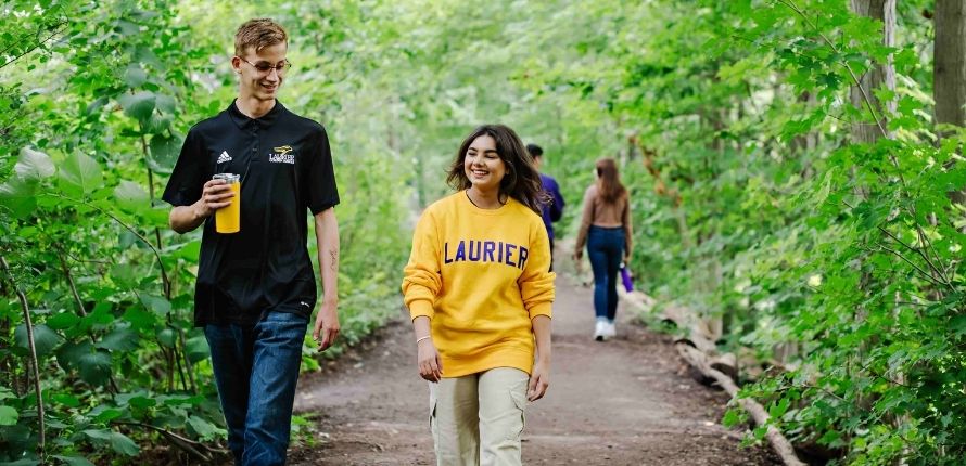 two people walking on a forest trail