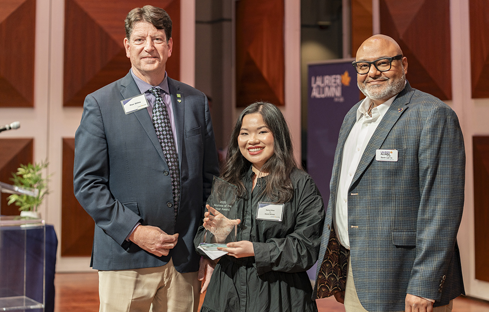 Rachel Phan is presented with Laurier's Alumna of the Year Award by Max Stiles and Kevin Lad
