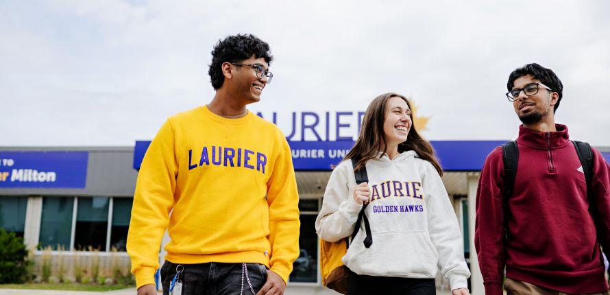 three students walking outside of laurier milton