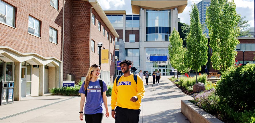 two students wearing Laurier gear walking outside on Waterloo campus