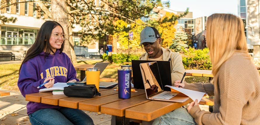 three students students studying outside in spring