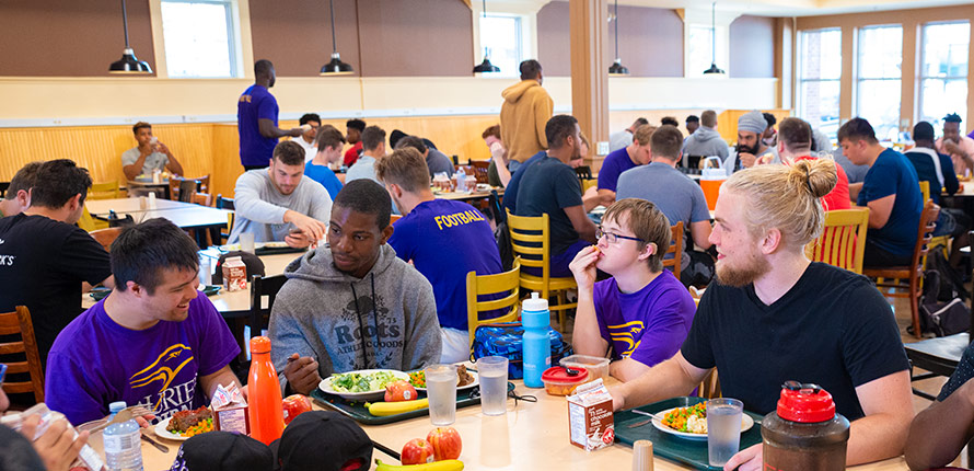 Laurier football players eating lunch with Light House members.