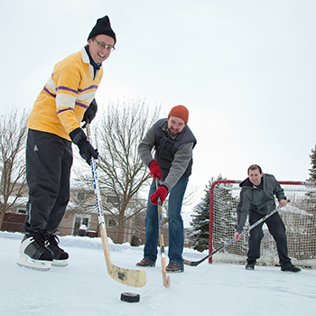 faculty playing hockey on outdoor rink