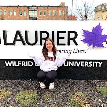 Madeline Campbell in front of Laurier sign