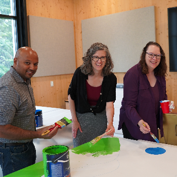 Lloyd Noronha, Deborah MacLatchy and Trish McLaren paint a mural panel