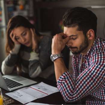 People sitting at table, stressed about bills