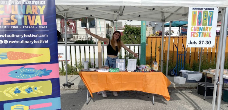 Linnea Azzolini behind a booth at culinary festival