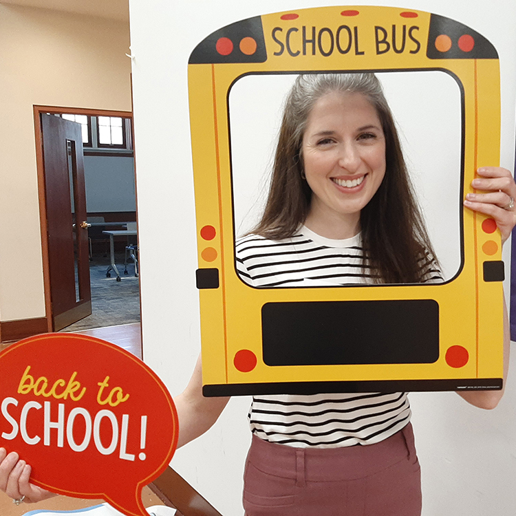 Young woman posing with school bus frame