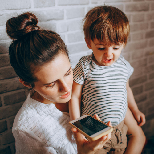 Mom holding toddler while on the phone