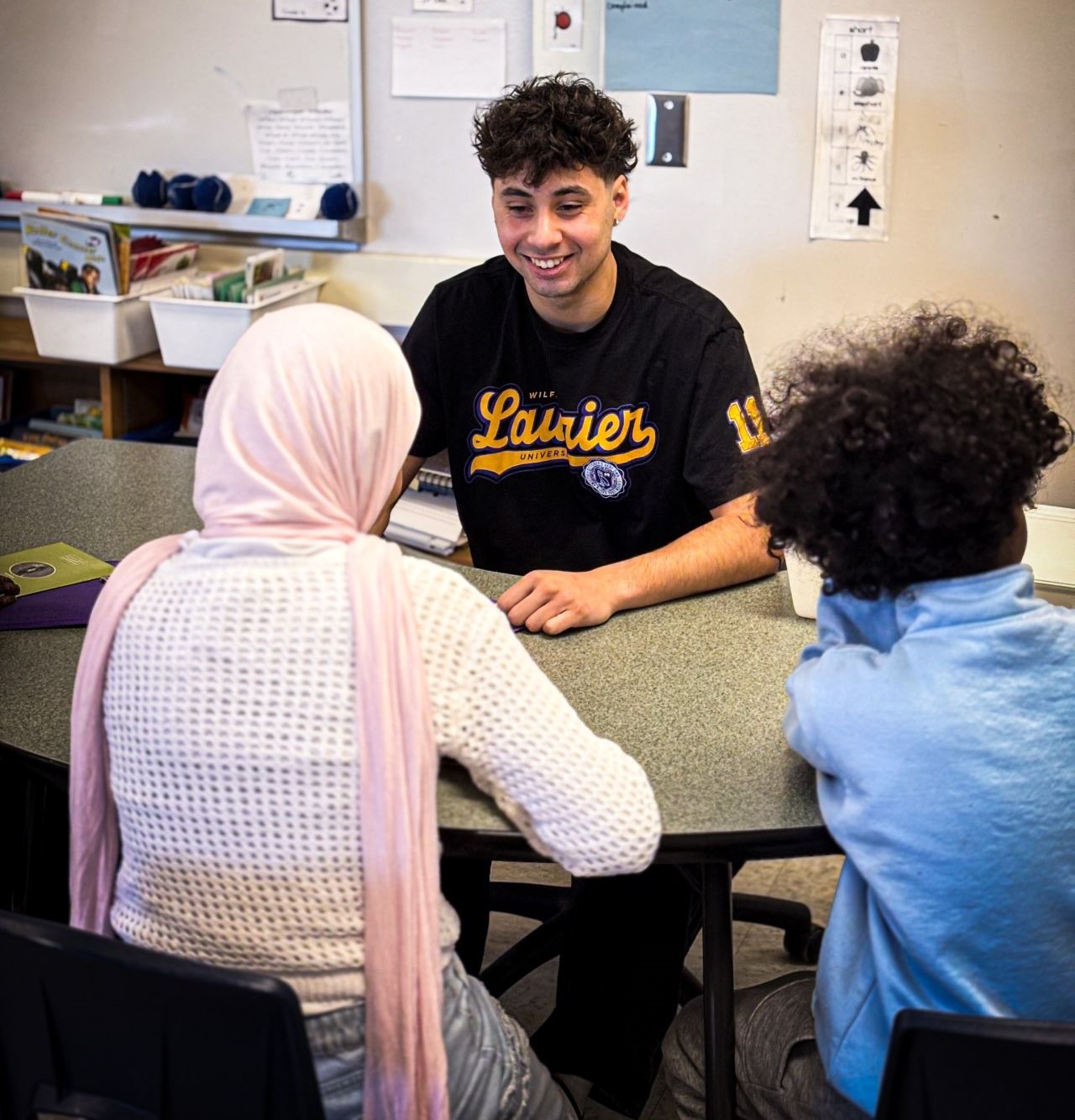 Laurier student teacher siting with students.