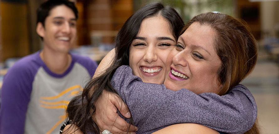 Parent hugging her daughter