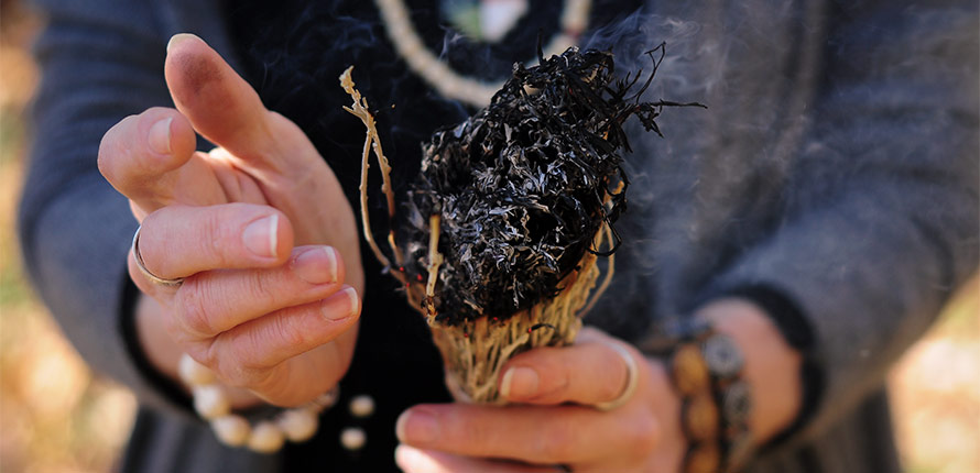 hands holding burning sage